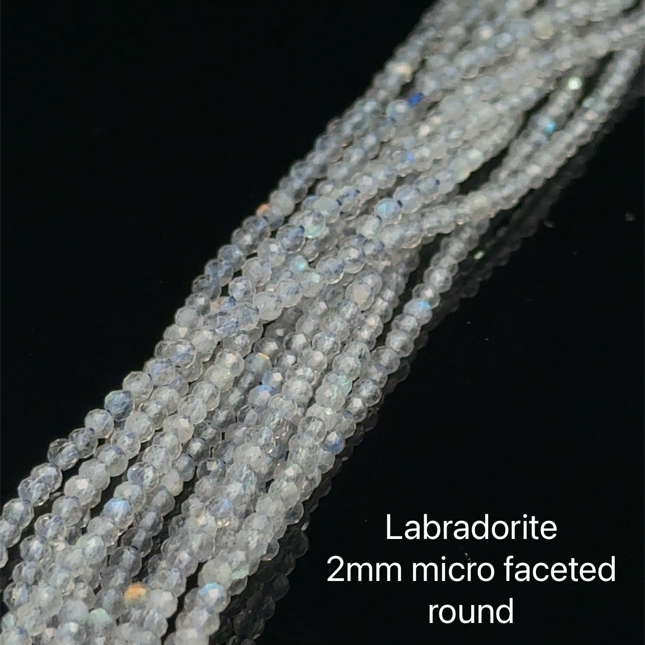2mm micro faceted round Labradorite beads on a white background, front overview. 