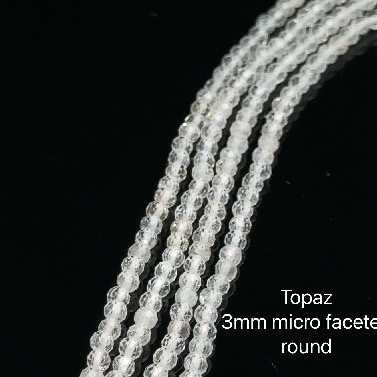 3mm Clear Topaz micro  faceted round gemstone strand, on a white background, front overview. 