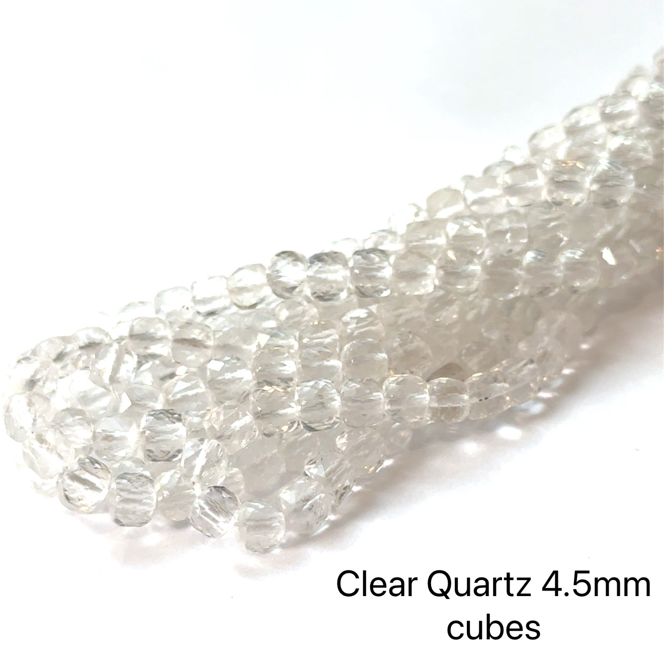 4.5mm Clear Quartz faceted cube gemstone strand on a white background, overview. 