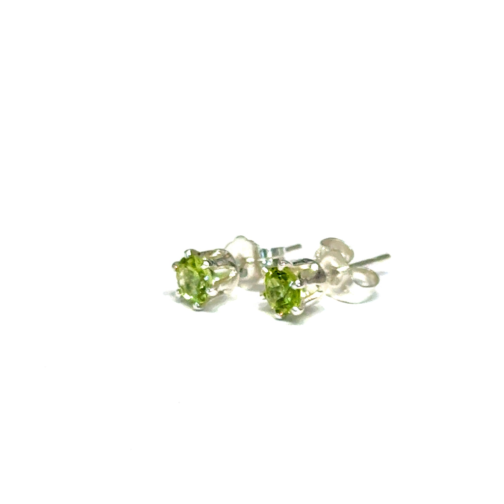 4mm round faceted Peridot stud earrings in sterling silver double prong setting on a white background  front left angle overview
