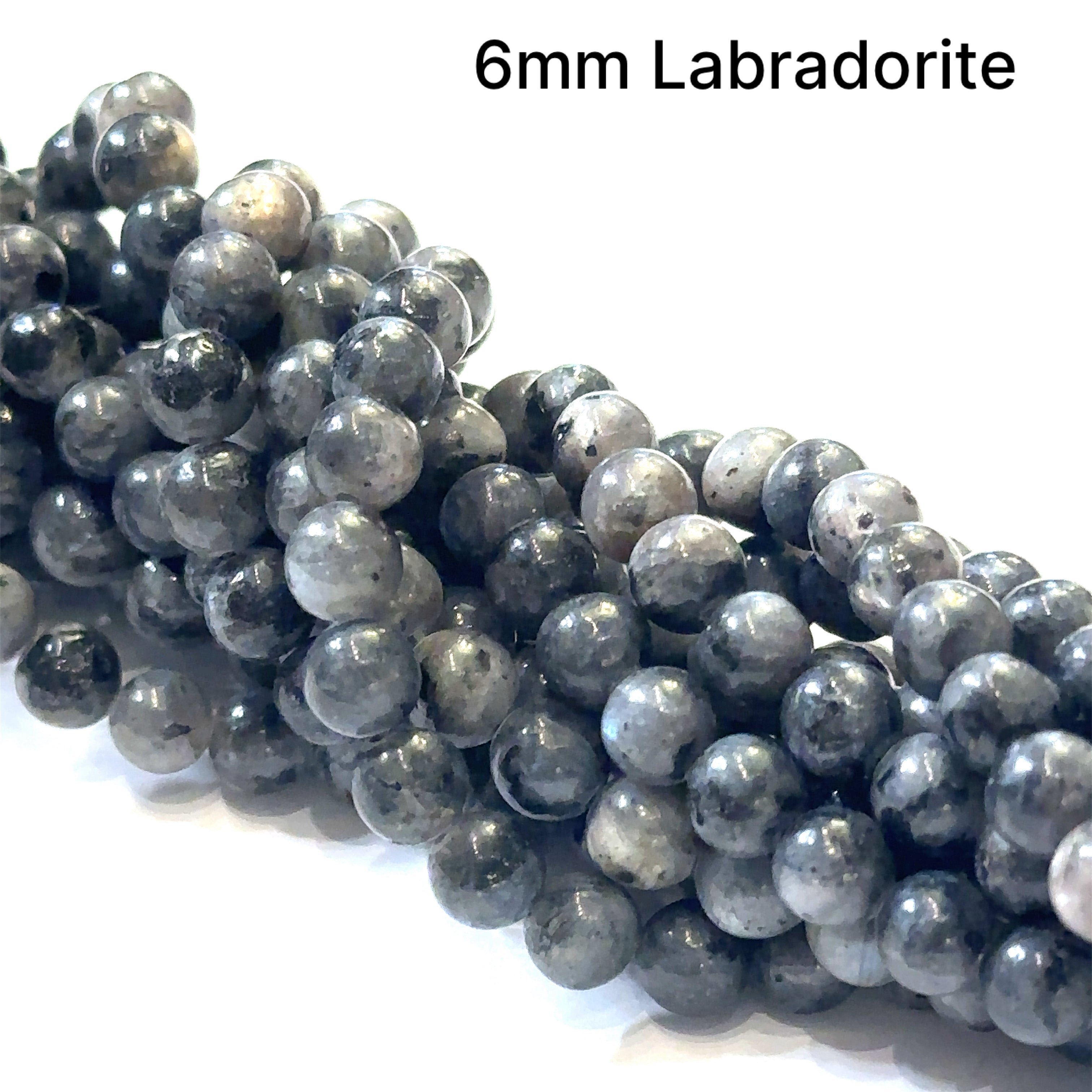 6mm smooth round black Labradorite beads on a white background, front overview.