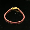 A 2mm micro faceted round Red garnet gemstone beaded bracelet with a gold-filled lobster claw on a black background, front view.