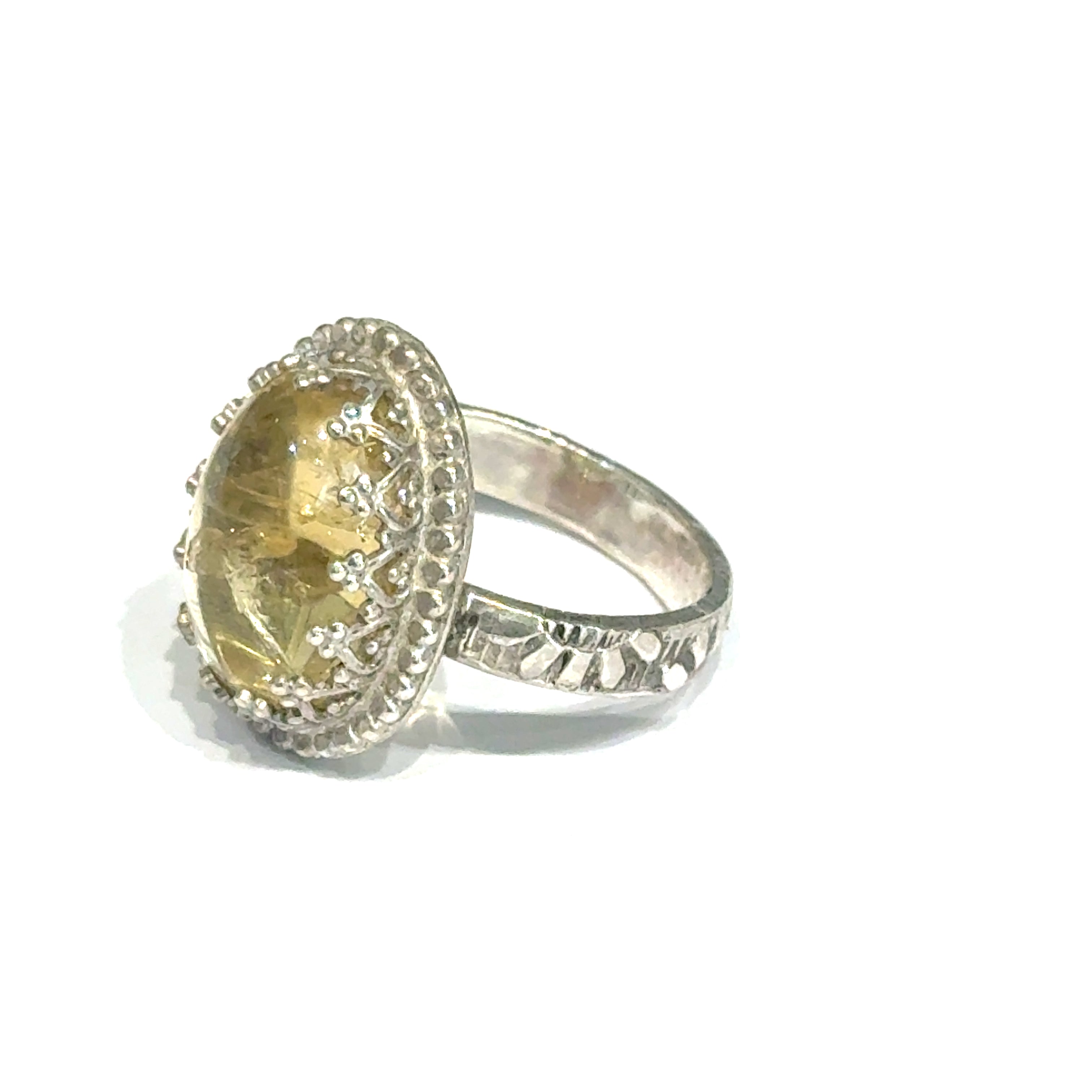 A Citrine Gemstone ring in sterling silver a vintage style on a white background left side, close up view.