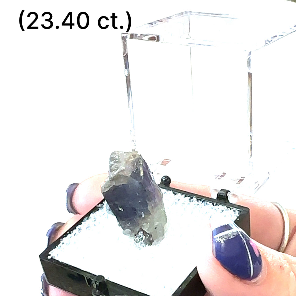 A Close-up of Tanzanite crystal in perky boxes showing deep violet-blue hues, on a white background, front view. size (23.40ct) gem grade.