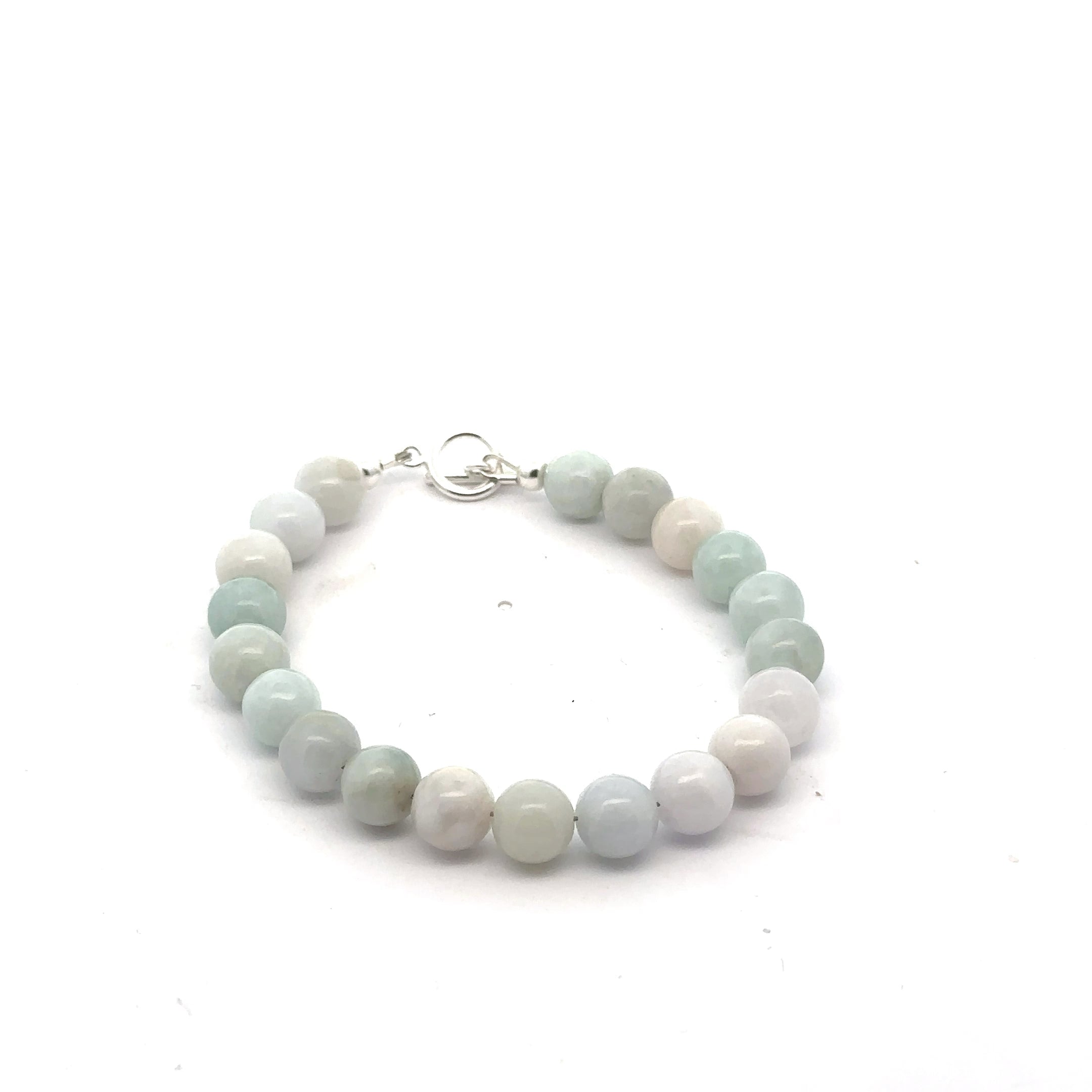 A Close-up of a 8mm polished Burma jade beads showing natural green color and smooth finish on a white back ground, front view. 