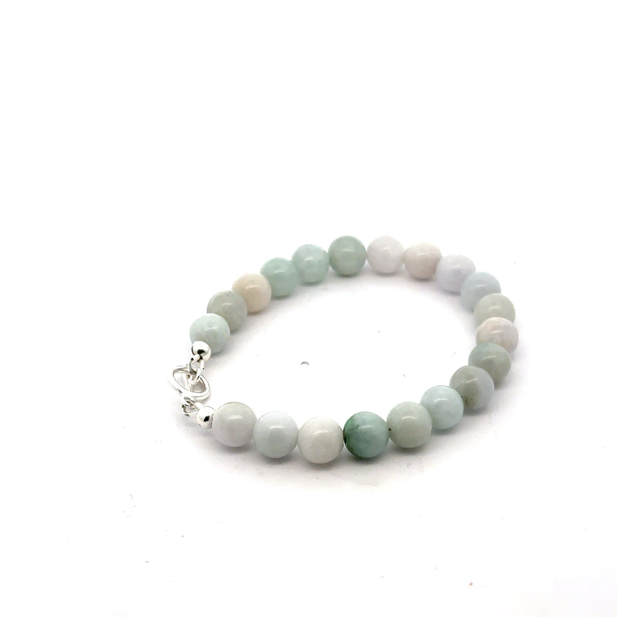 A Close-up of a 8mm polished Burma jade beads showing natural green color and smooth finish on a white background, back right angle view.