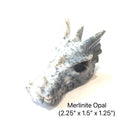 A Dendritic (Merlinite) Opal gemstone dragon head carving on a white background, right angle overview. 