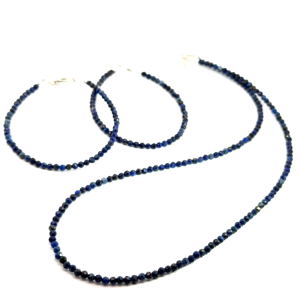 A Lapis Lazuli gemstone beaded necklace with on a matching bracelets white background long overview, front overview.