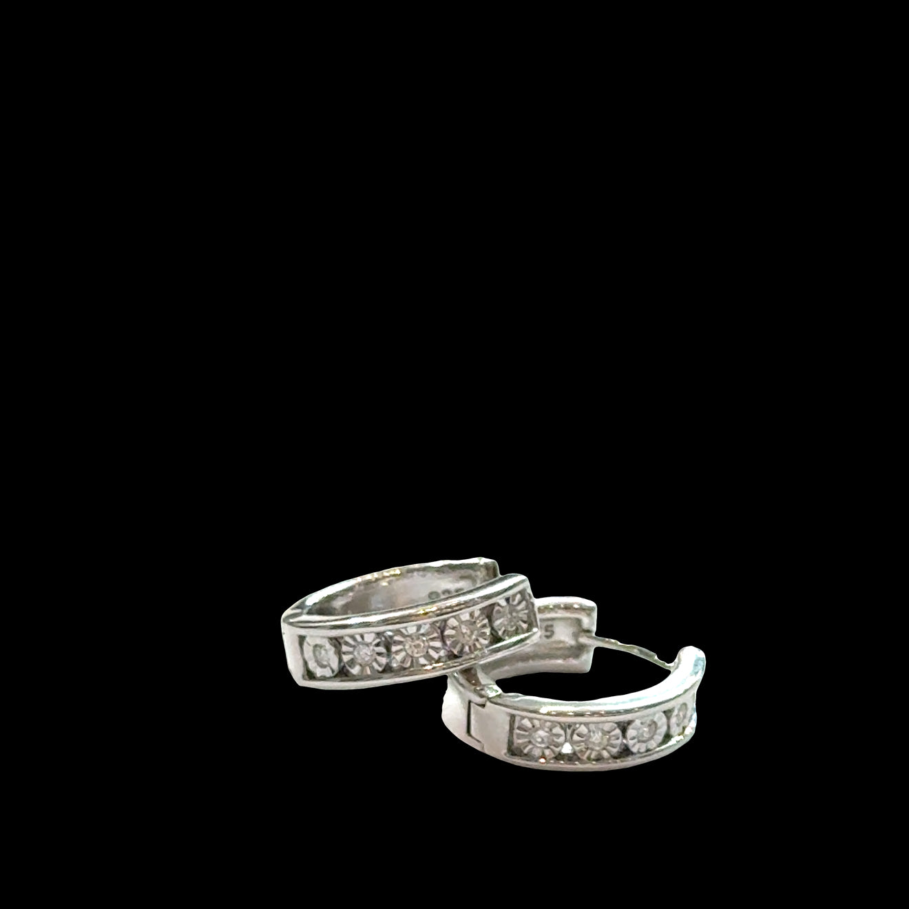 A Sterling Silver .8ct 10 Lab Grown Diamond channel set huggie hoop earrings on a black background, front view. 