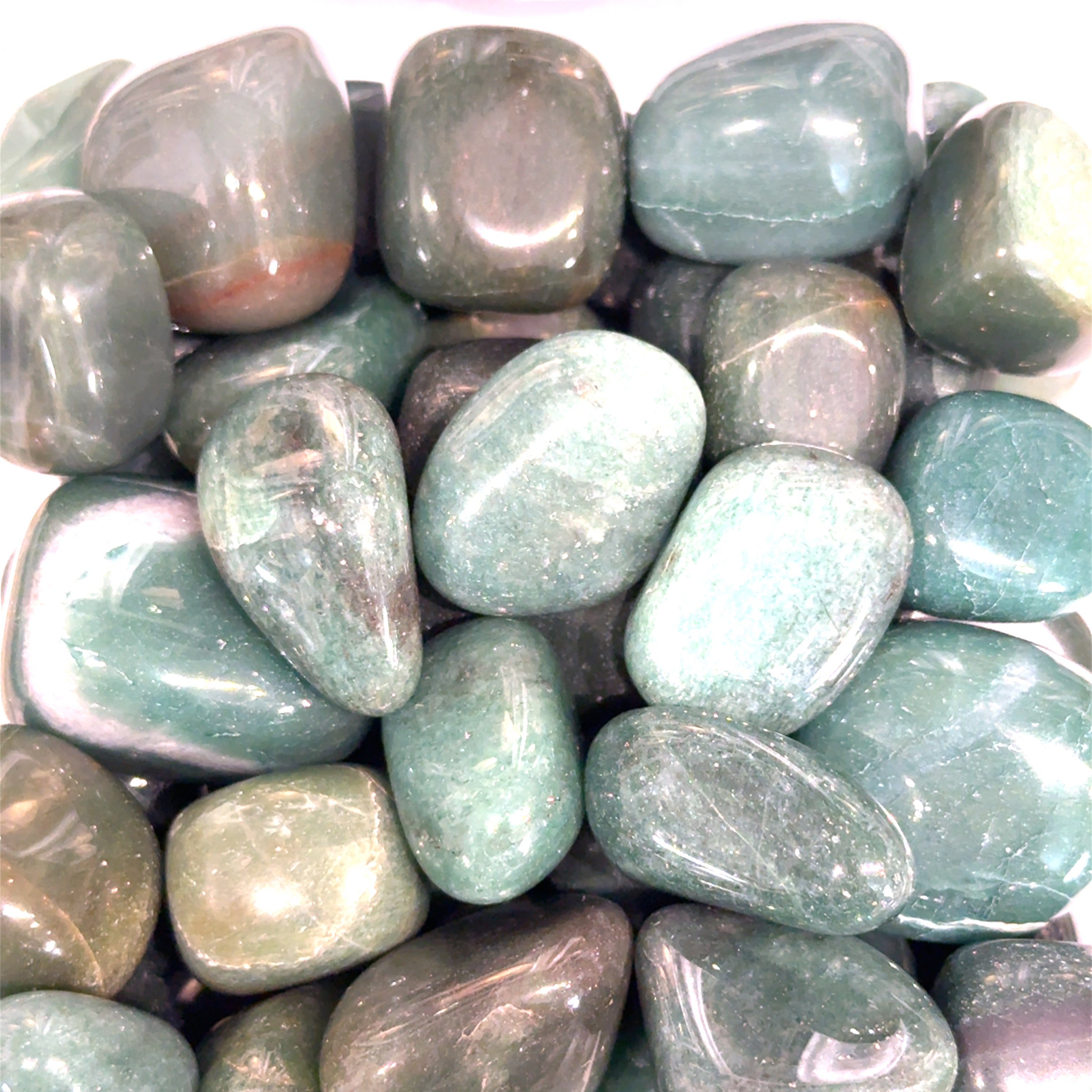 A collection of Green Aventurine tumbled gemstones on a white background, front view.
