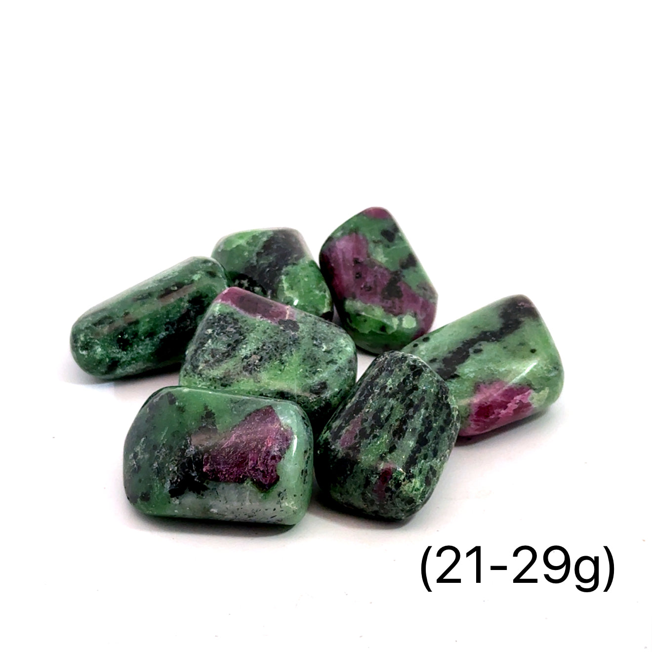 A collection of Ruby in Zoisite tumbled gemstones varying in shades of green with hints of purple, displayed on a white surface. The size of the stones is indicated as 2-29 grams.