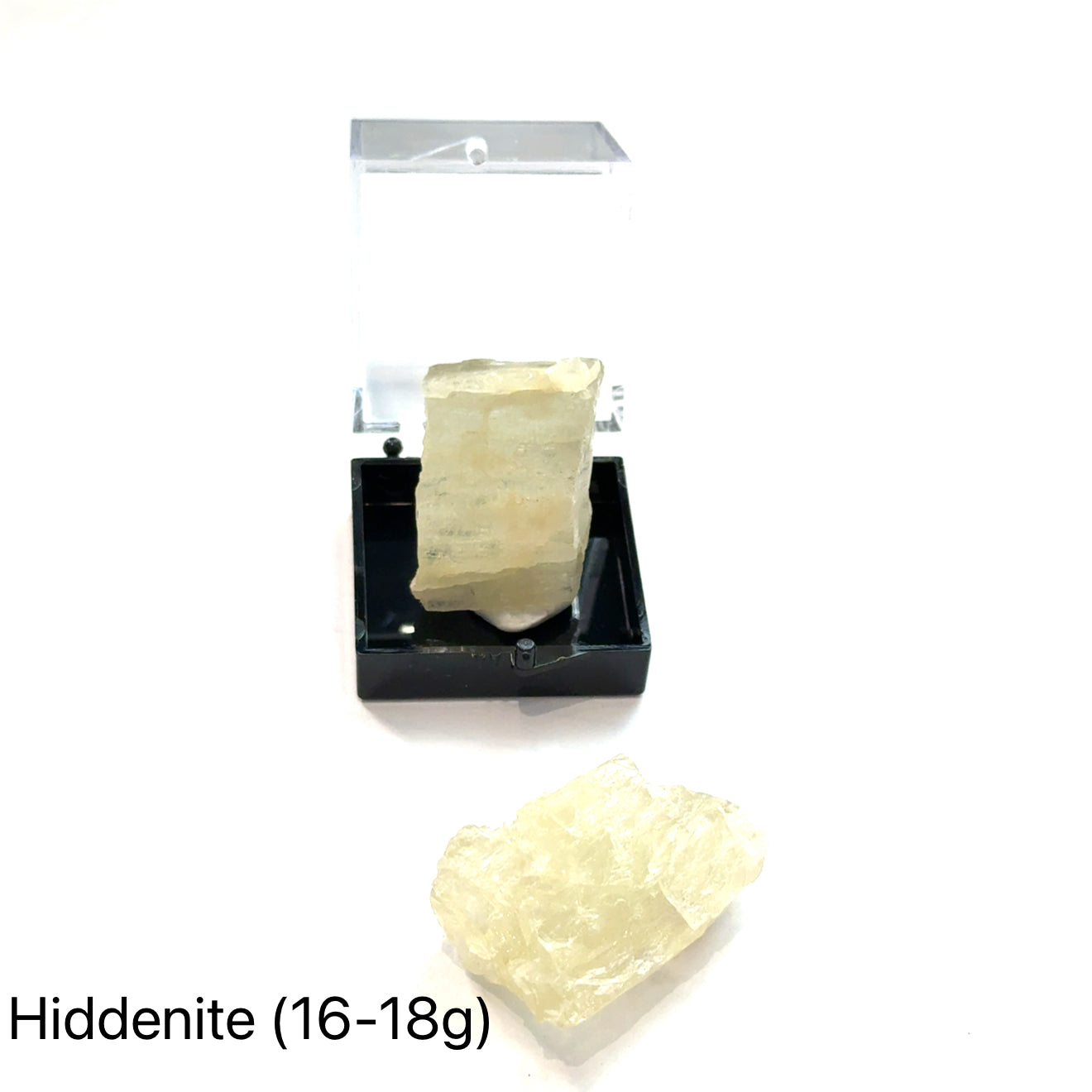 A collection of raw Hiddenite gemstones displayed on a white surface. (16-18g) front overview.