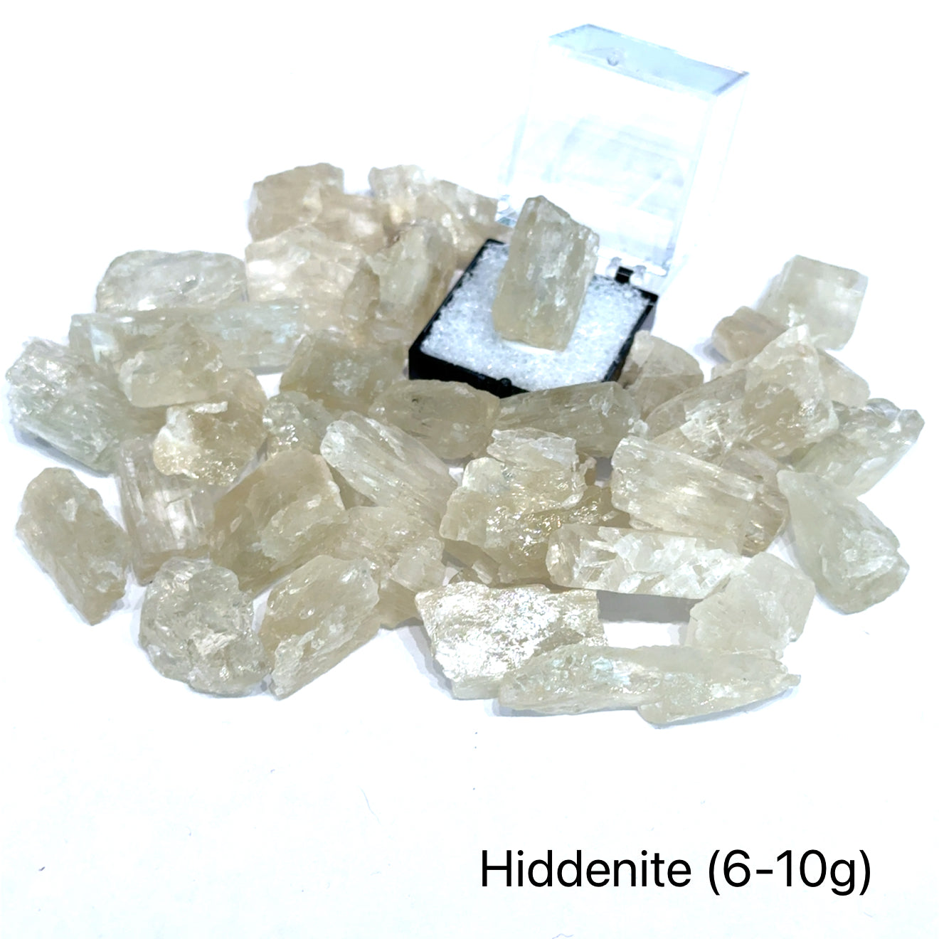 A collection of raw Hiddenite gemstones displayed on a white surface. (6-10g) front overview.