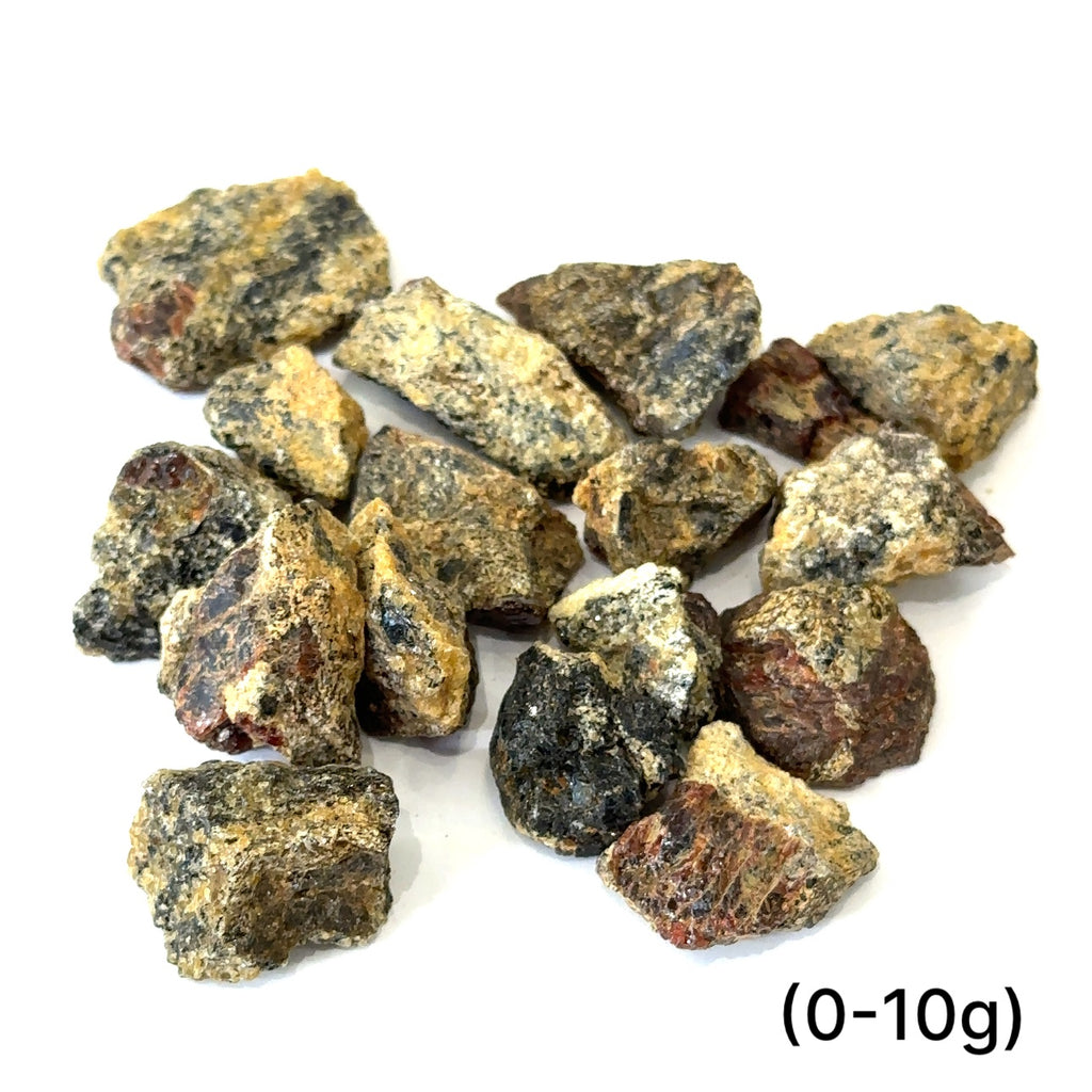 A collection of raw garnet gemstones with a rough, rugged texture in a natural color range of red and brown. On white (0-20g) overview
