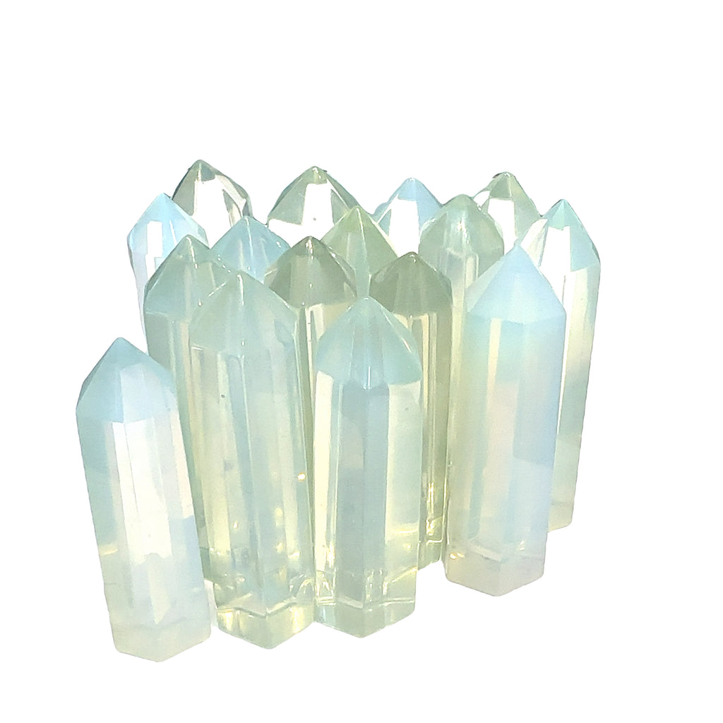 A collection of  transparent multicolored opalite gemstone tower against a white background, front view. 