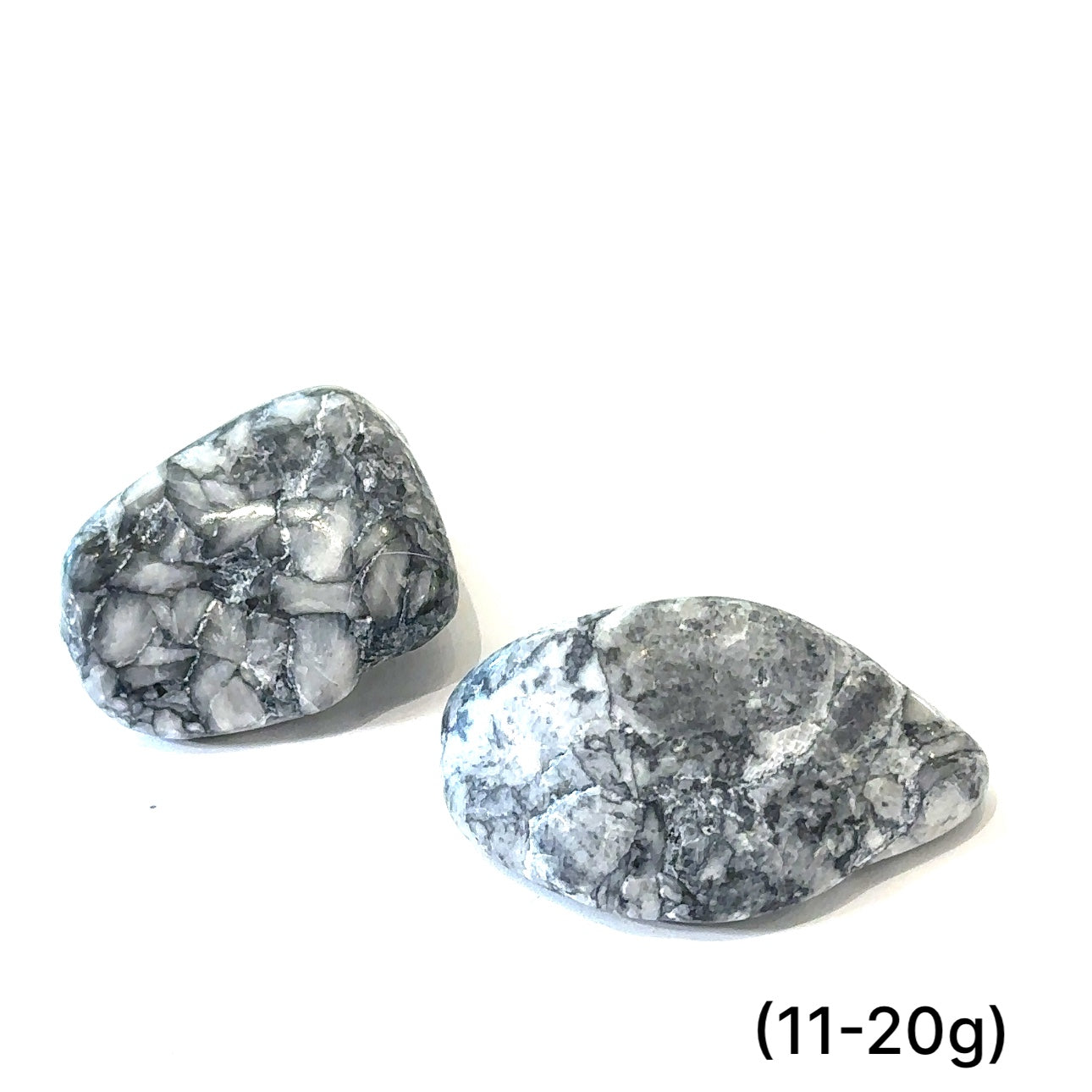 A collection of tumbled Pinolith gemstones (11-20g) displayed on a white background, with varying shades of gray and white patterns.