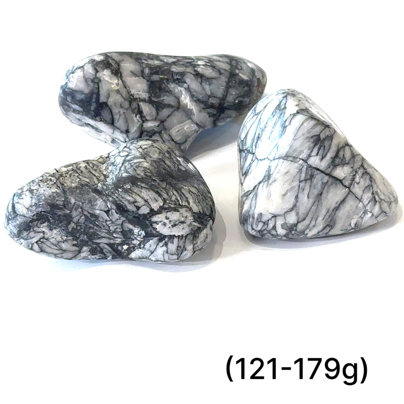 A collection of tumbled Pinolith gemstones (121-179g) displayed on a white background, with varying shades of gray and white patterns.