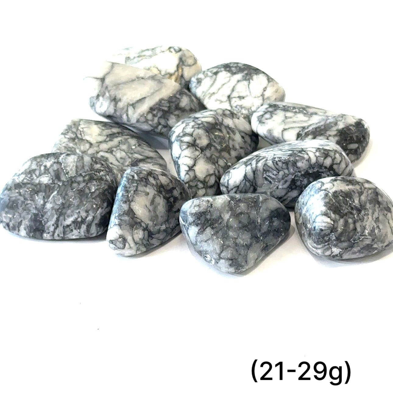 A collection of tumbled Pinolith gemstones (21-29g) displayed on a white background, with varying shades of gray and white patterns.