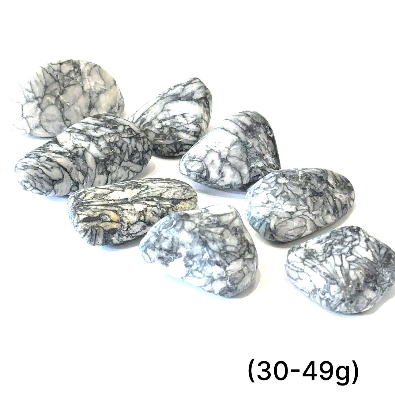 A collection of tumbled Pinolith gemstones (30-49g) displayed on a white background, with varying shades of gray and white patterns.