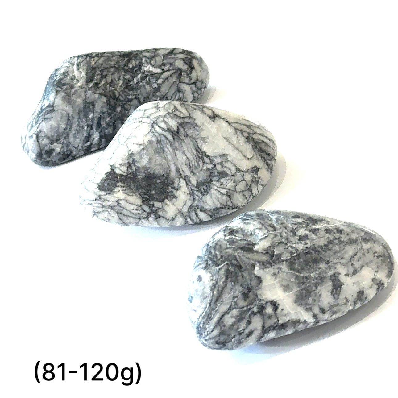 A collection of tumbled Pinolith gemstones (81-120g) displayed on a white background, with varying shades of gray and white patterns.
