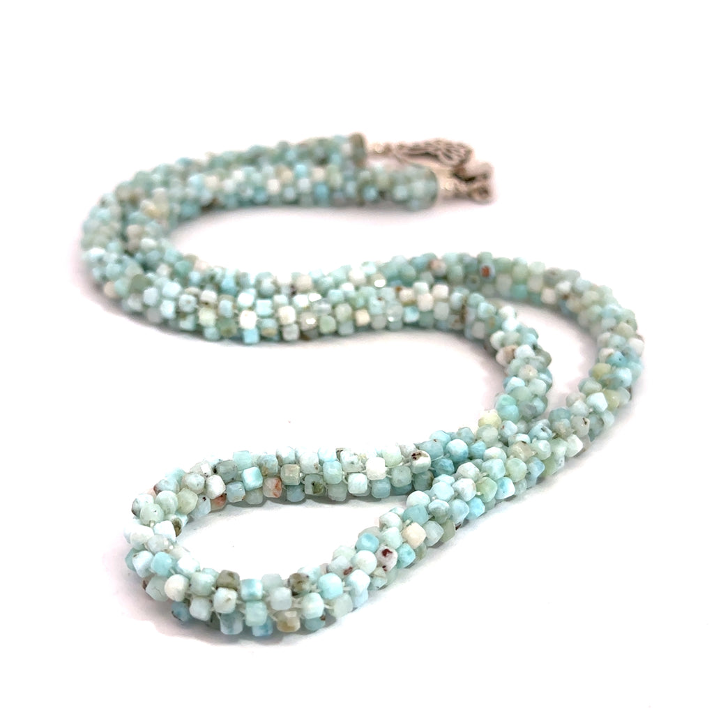A crocheted necklace made with Larimar gemstone beads and a sterling silver butterfly box clasp on a white background, long front view. 