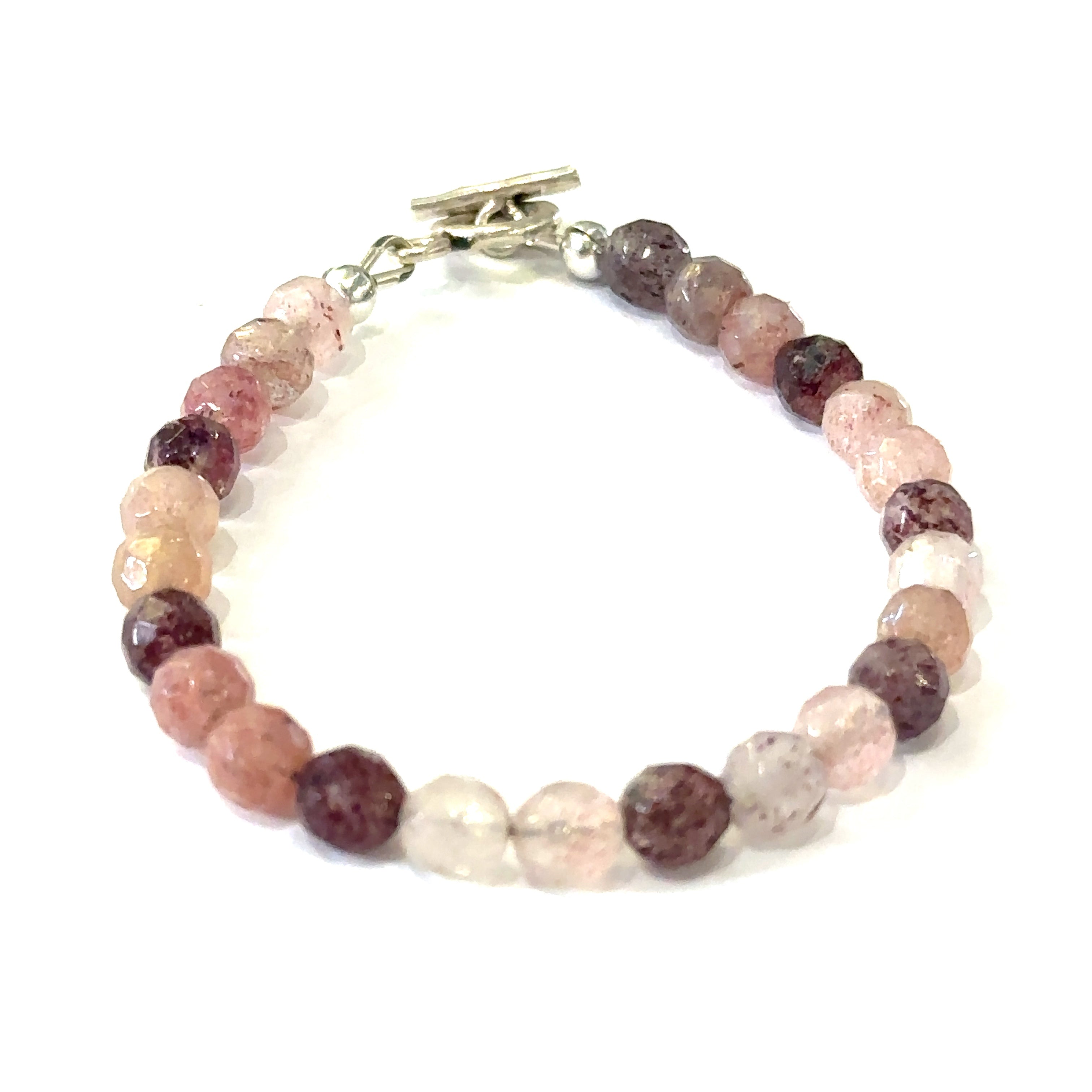 A genuine Strawberry Quartz gemstone bracelet with faceted beads and a aterling silver toggle on a white background, with a front center overview. 