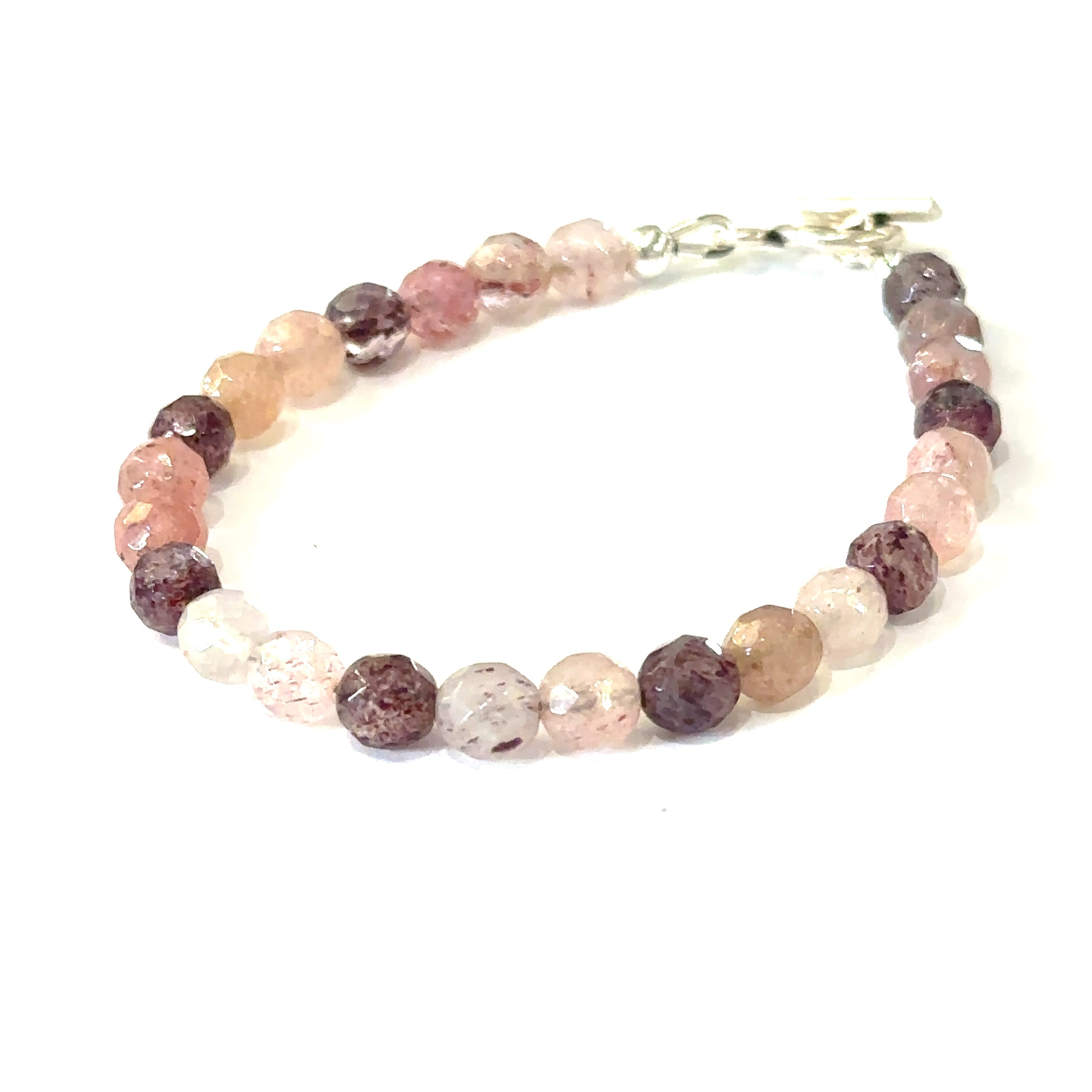 A genuine Strawberry Quartz gemstone bracelet with faceted beads and a aterling silver toggle on a white background, with a front slight left angle overview. 