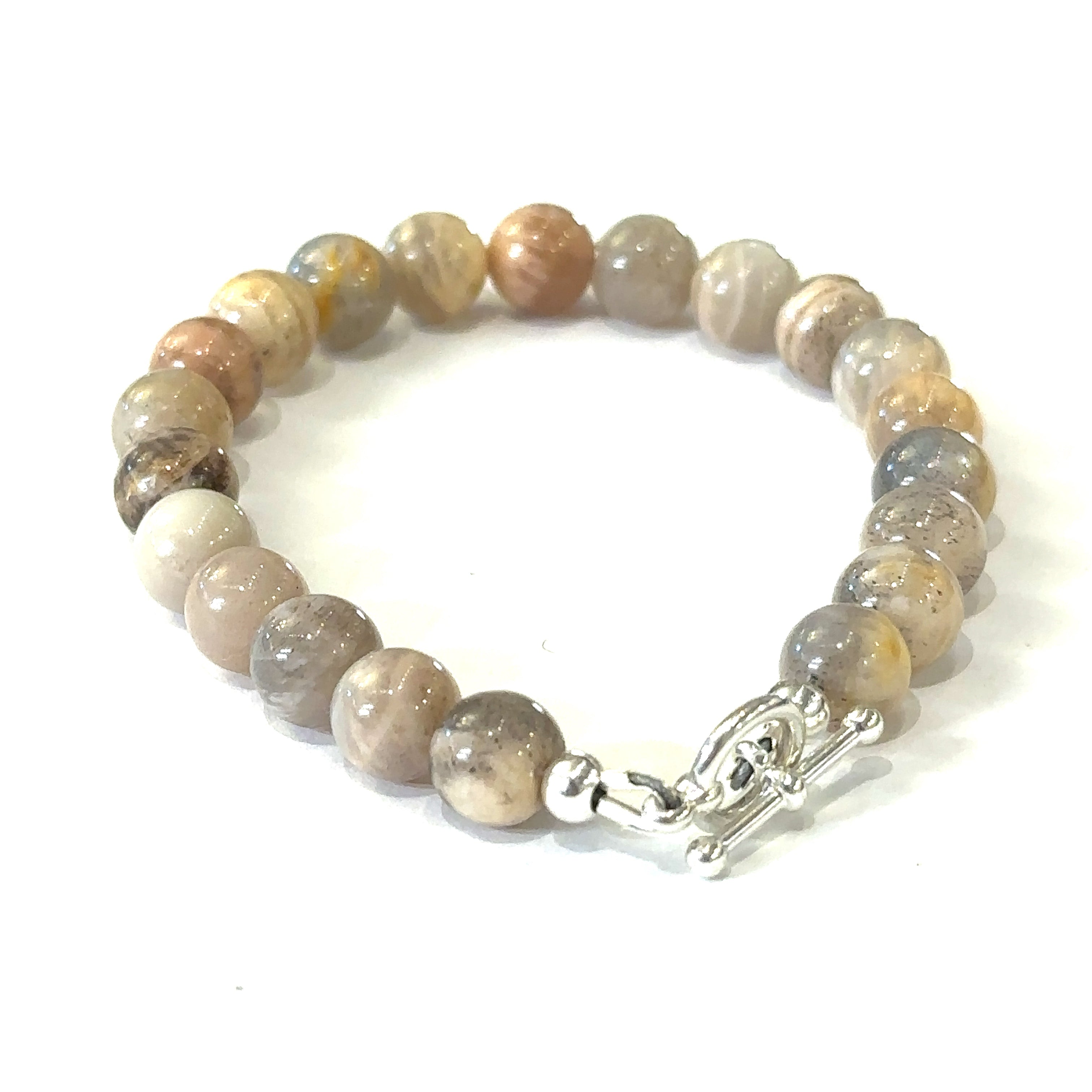 A greyish peach Moonstone gemstone beaded bracelet with a sterling silver toggle clasp on a white background, back, overview. 