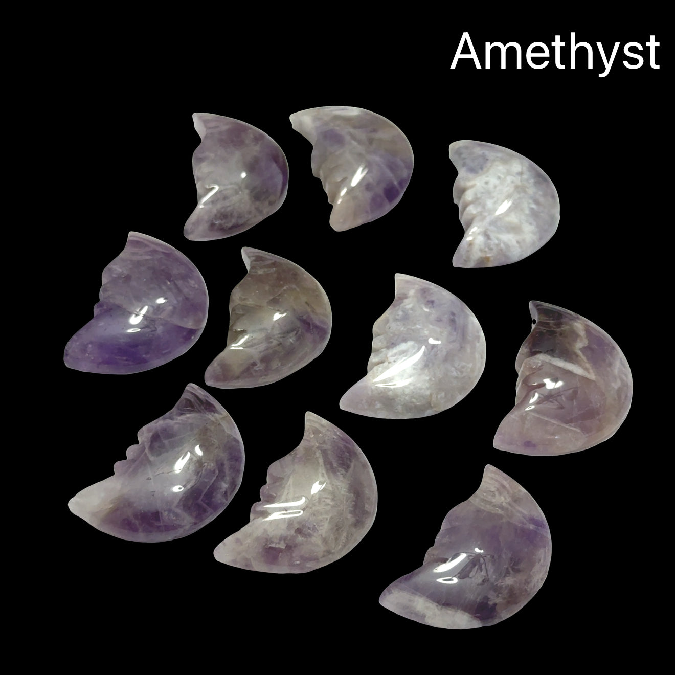 A group of Amethyst Gemstone moon carvings on a black background, front view.