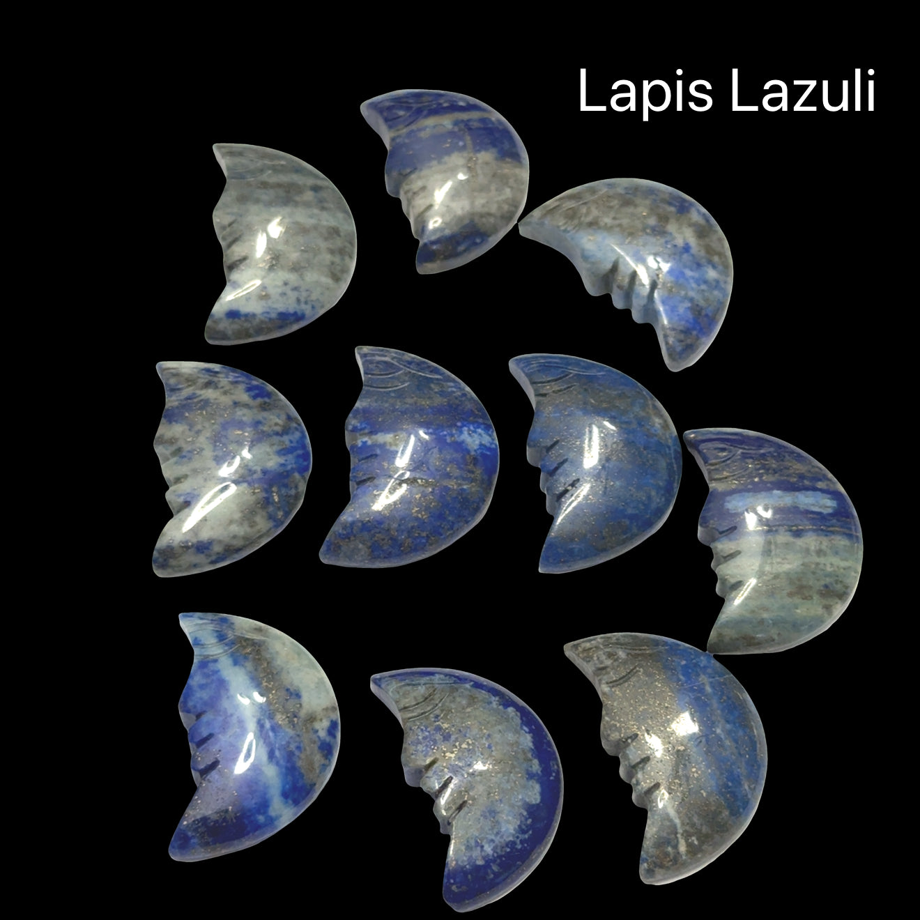 A group of Lapis Lazuli Gemstone moon carvings on a black background, front view.