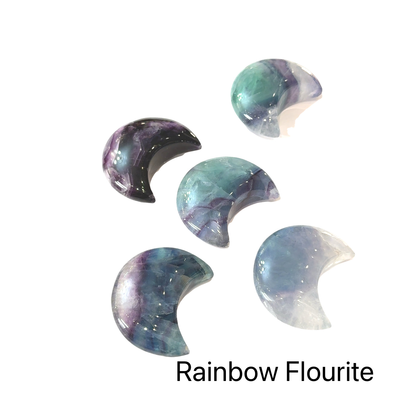 A group of Rainbow Fluorite Gemstone moon carvings on a black background, front view.