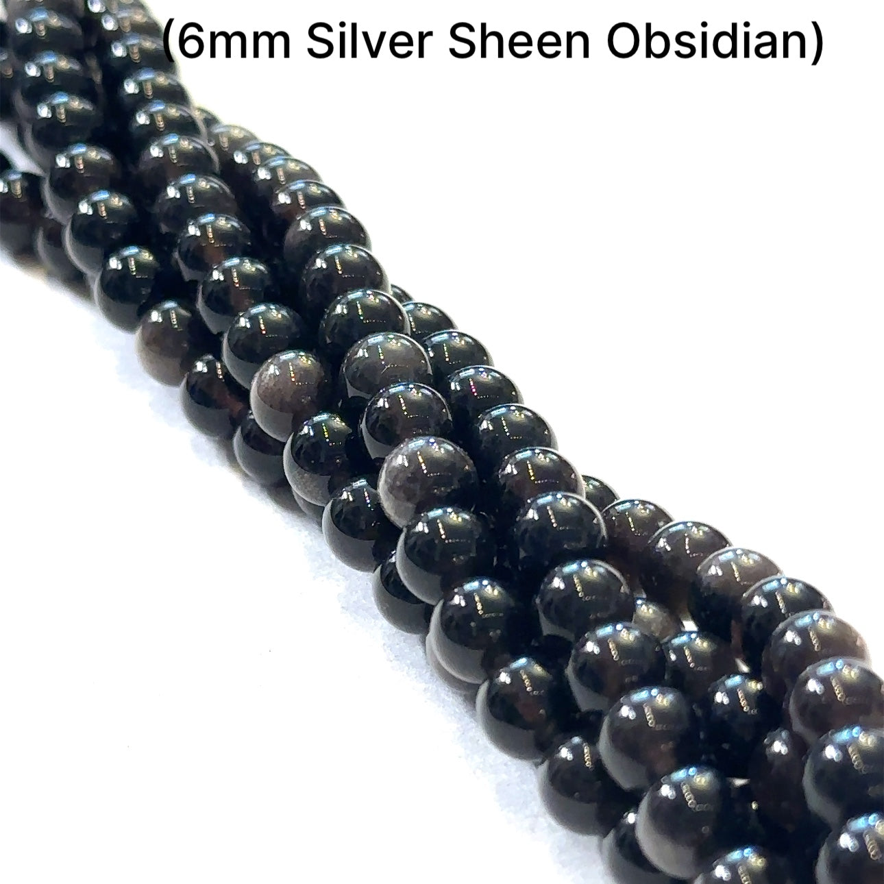 A group of strands of 6mm Silver Sheen Obsidian gemstone beads on a white background, front overview. 