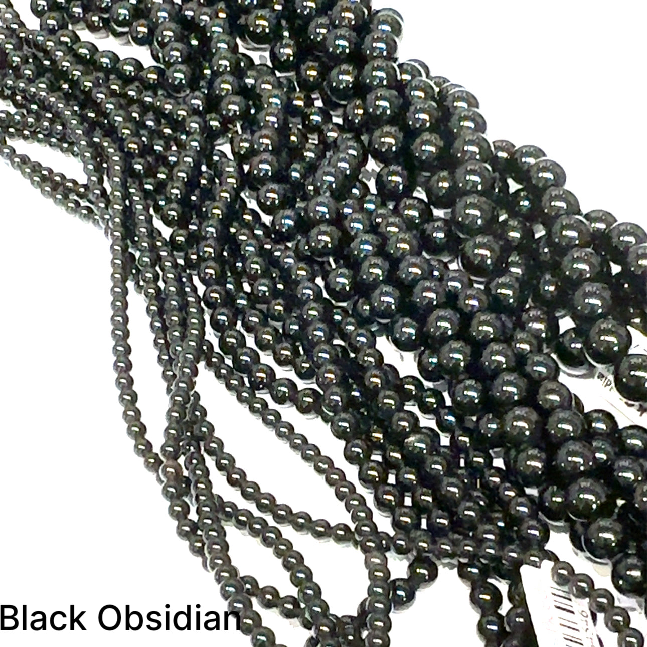 A group of strands of black obsidian gemstone beads on a white background, front overview. 