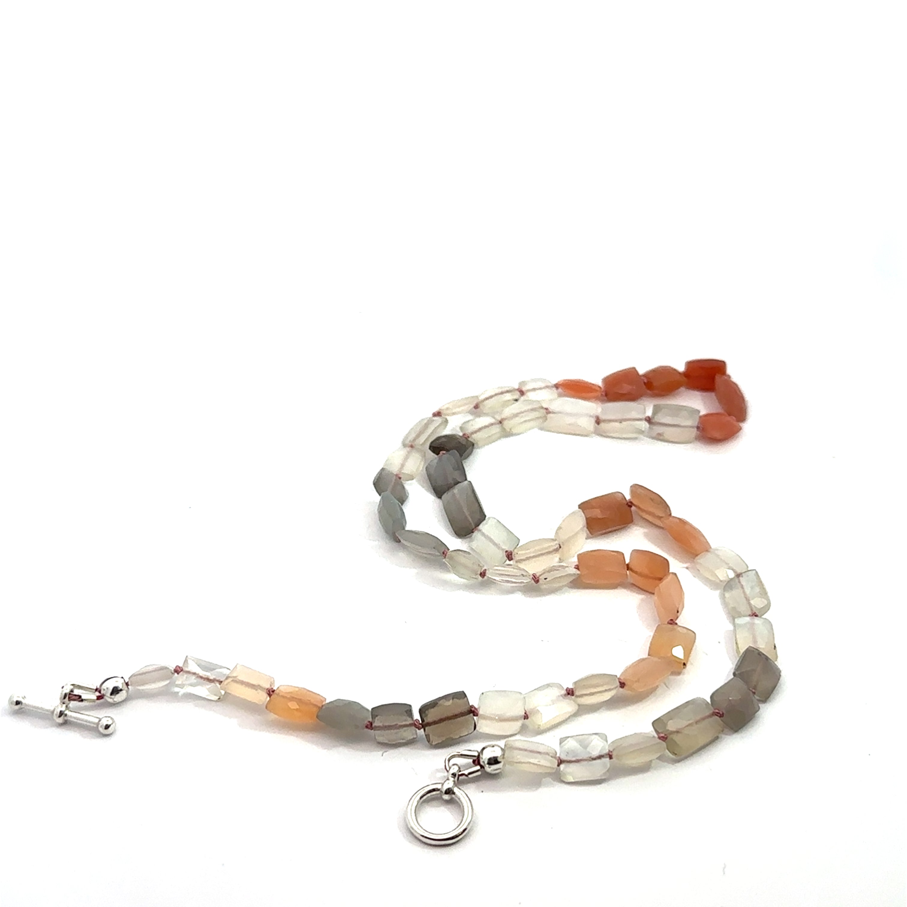 A knotted necklace made of mixed moonstone gemstones with a sterling silver toggle clasp on a white background, long back overview 