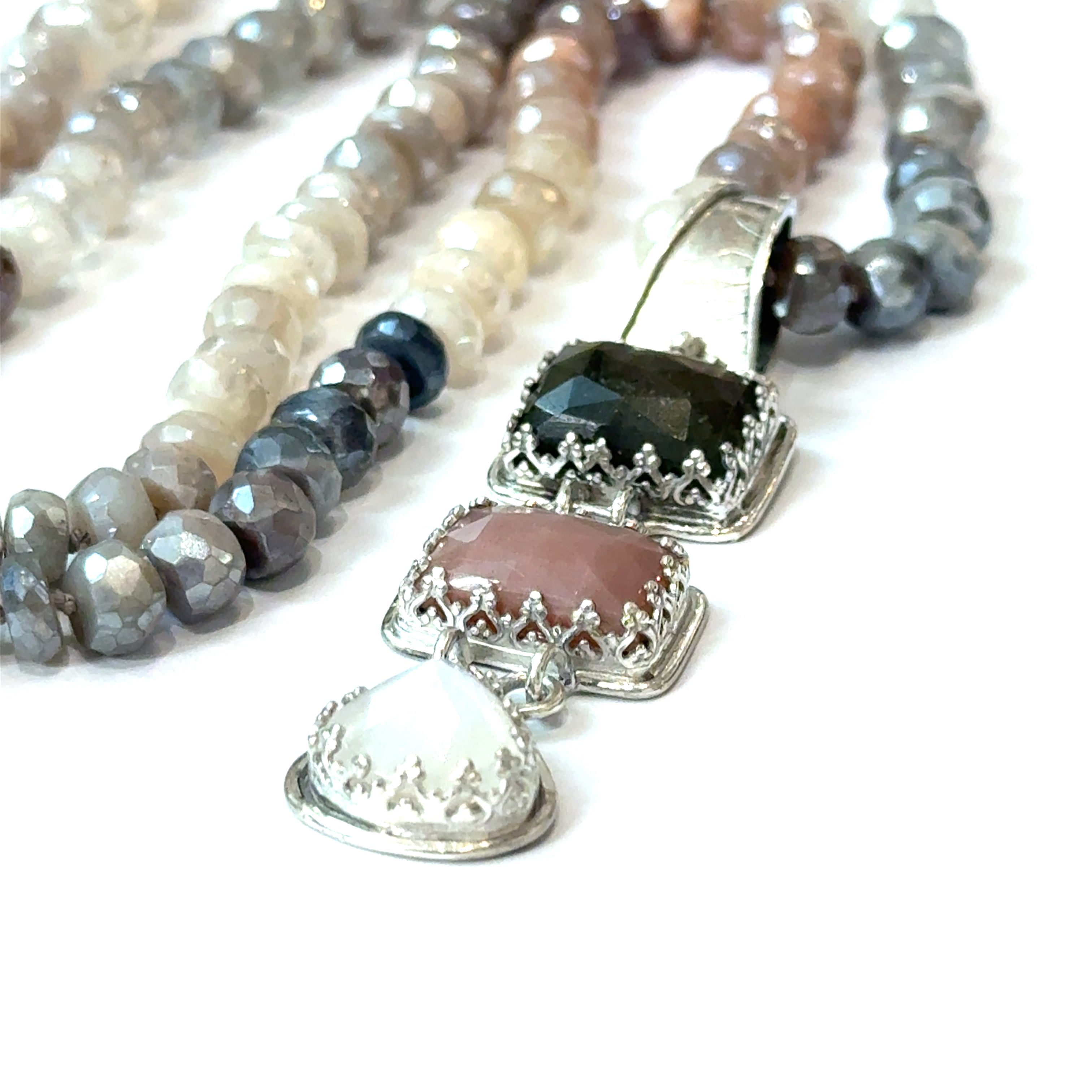 A mixed moonstone faceted roundel knotted necklace with a custom forged sterling silver with three gemstones pendant. on a white background, front close up overview. 