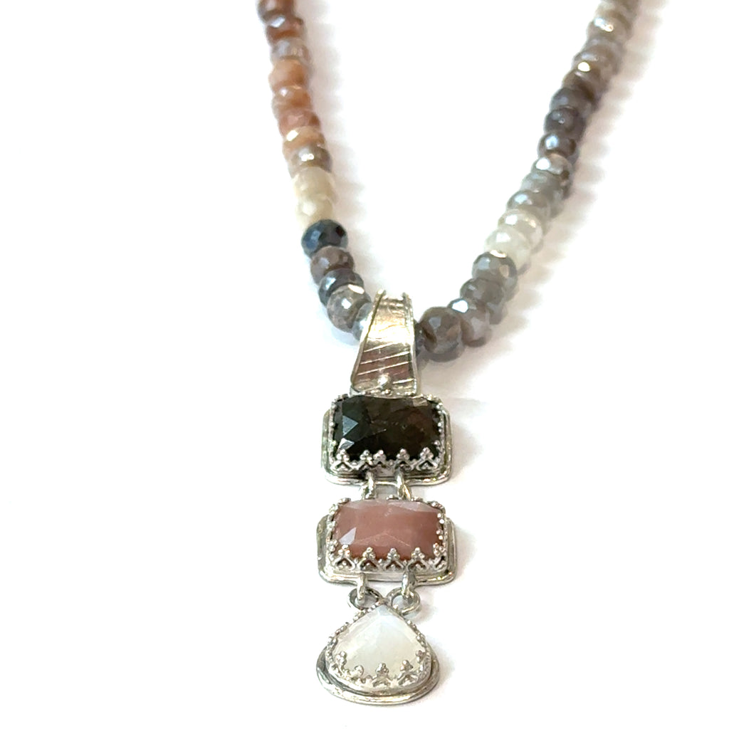 A mixed moonstone faceted roundel knotted necklace with a custom forged sterling silver with three gemstones pendant. on a white background, front hung overview. 
