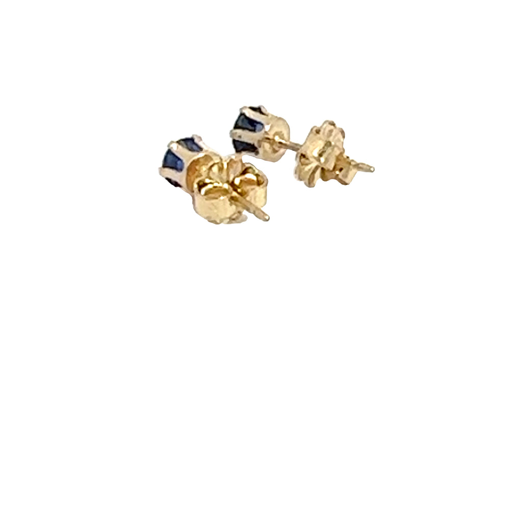 A pair of blue sapphire stud earrings with 14k gold-filled baskets and gold-filled push-backs on a white background, back left angle overview. 