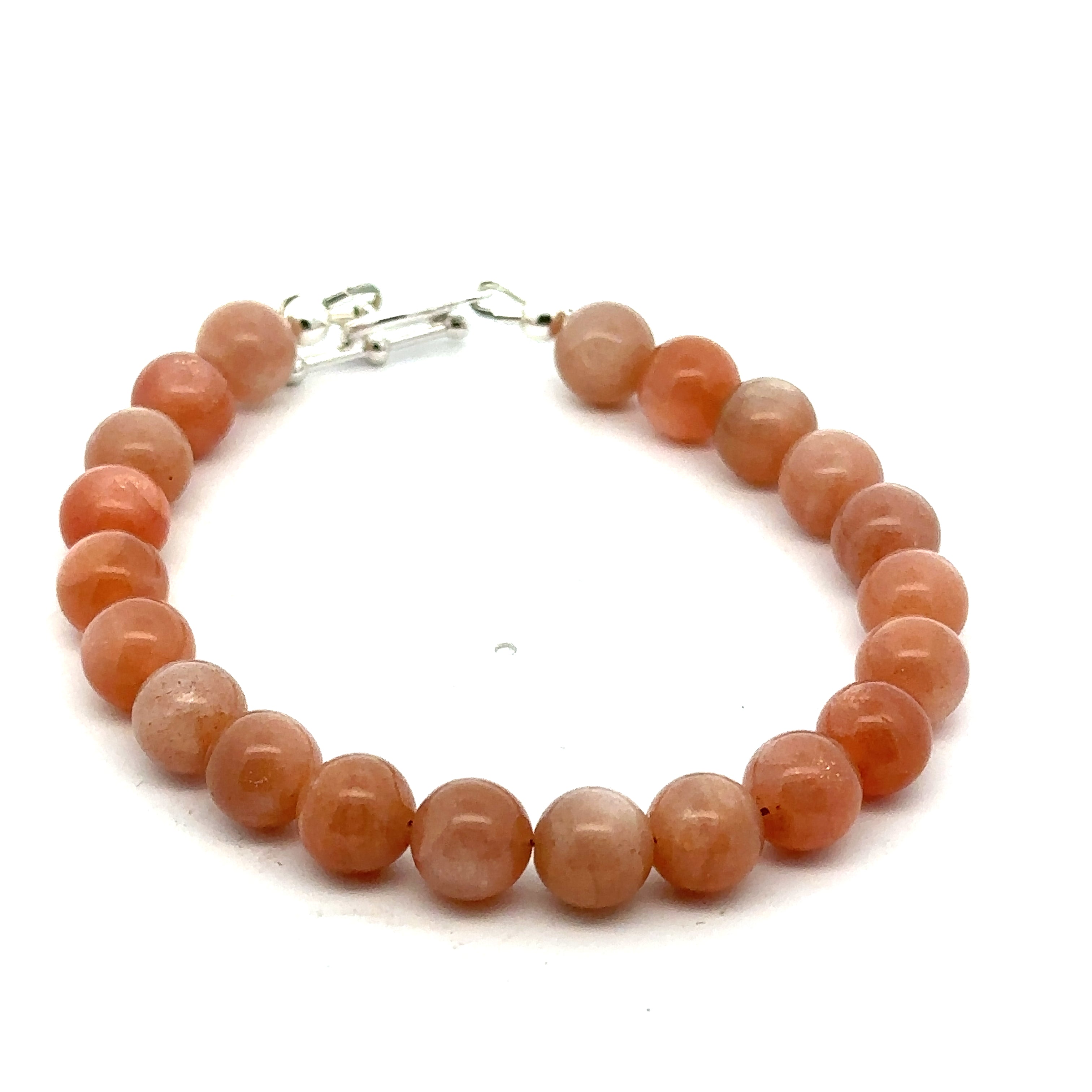 A peach Moonstone gemstone beaded bracelet with a sterling silver toggle clasp on a white background, front, overview. 