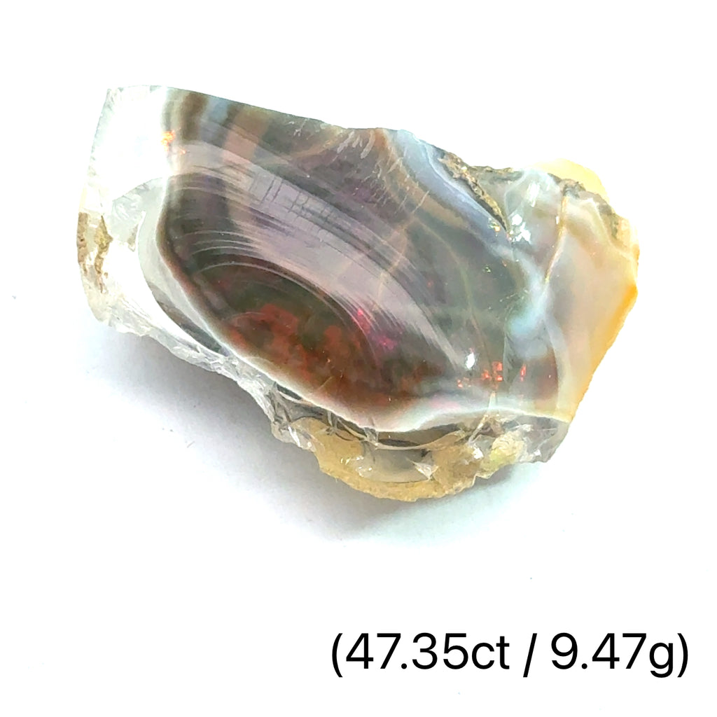 A raw Ethiopian opal gemstones with varying colors, displayed on a white background, 9.47g.