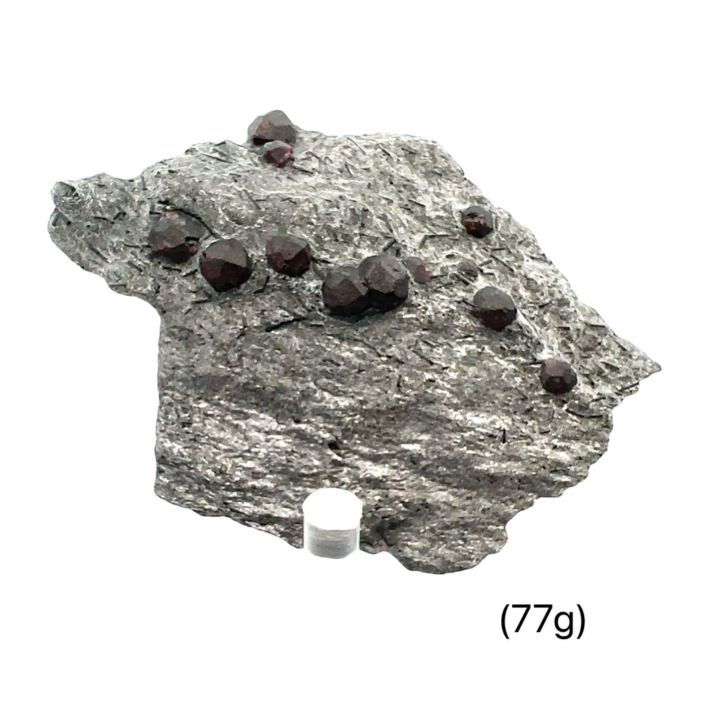 Almandine Garnet Raw Gemstone with Graphite on white displayed with stand 77g