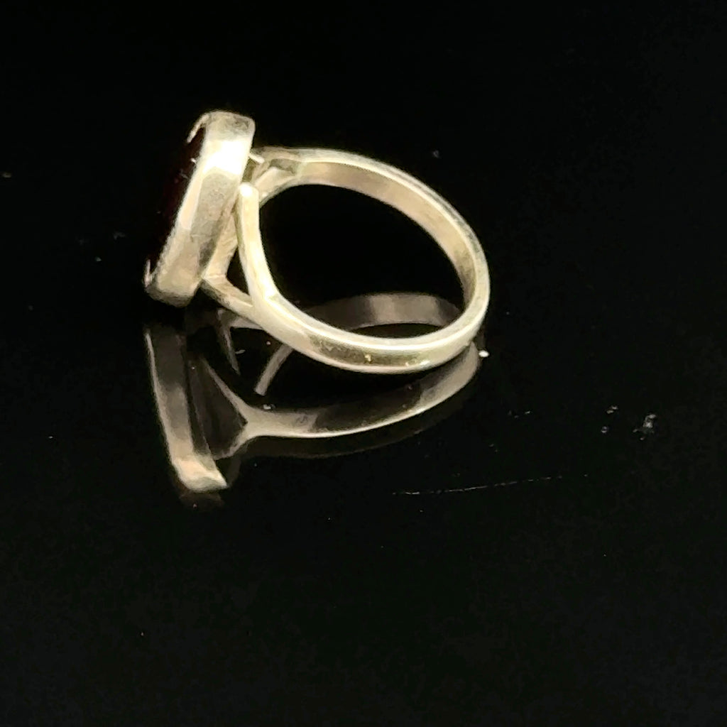 Almandine Garnet gemstone sterling silver ring  on a black background, right side overview. 