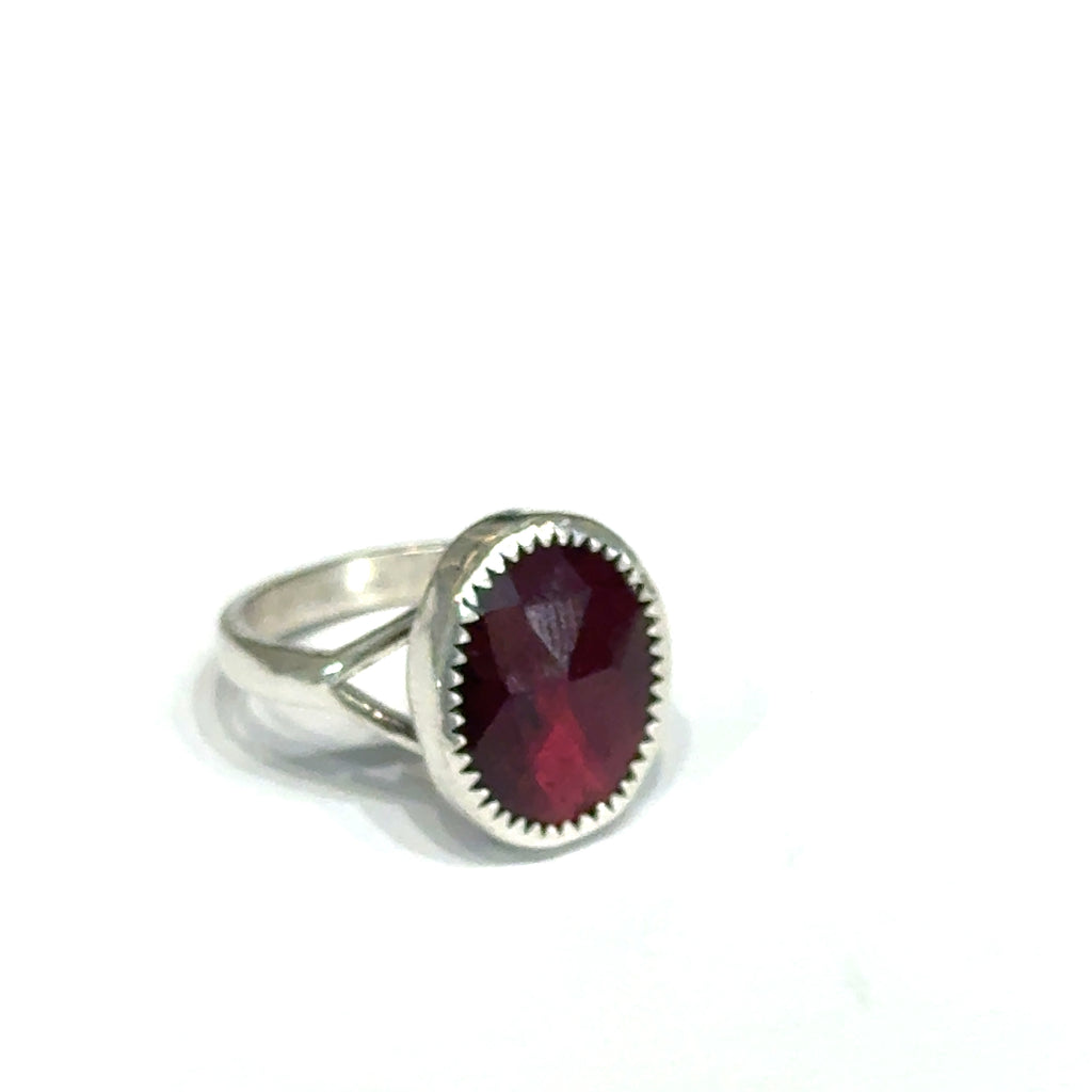 Almandine Garnet gemstone sterling silver ring  on a white background, left side overview. 