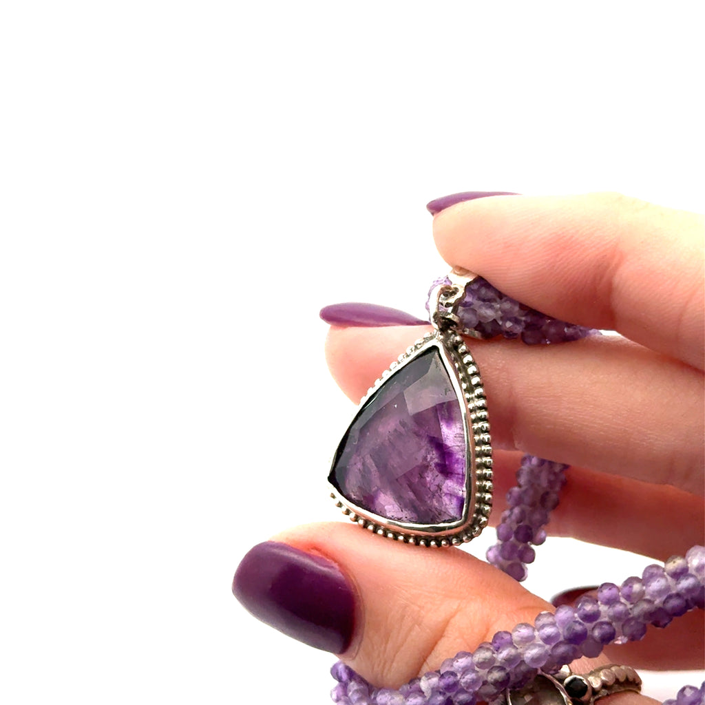 Reiki jewelry in Boston handmade with ethically sourced amethyst gemstones  on white in hand center view