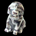 Amethyst Trapiche Gemstone Carved  Dog on a black background, front view.
