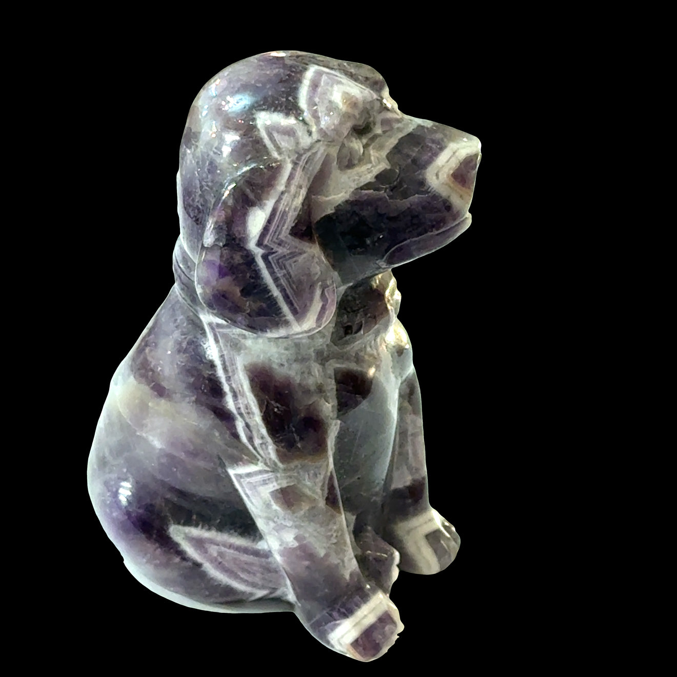 Amethyst Trapiche Gemstone Carved  Dog on a black background, left side view.
