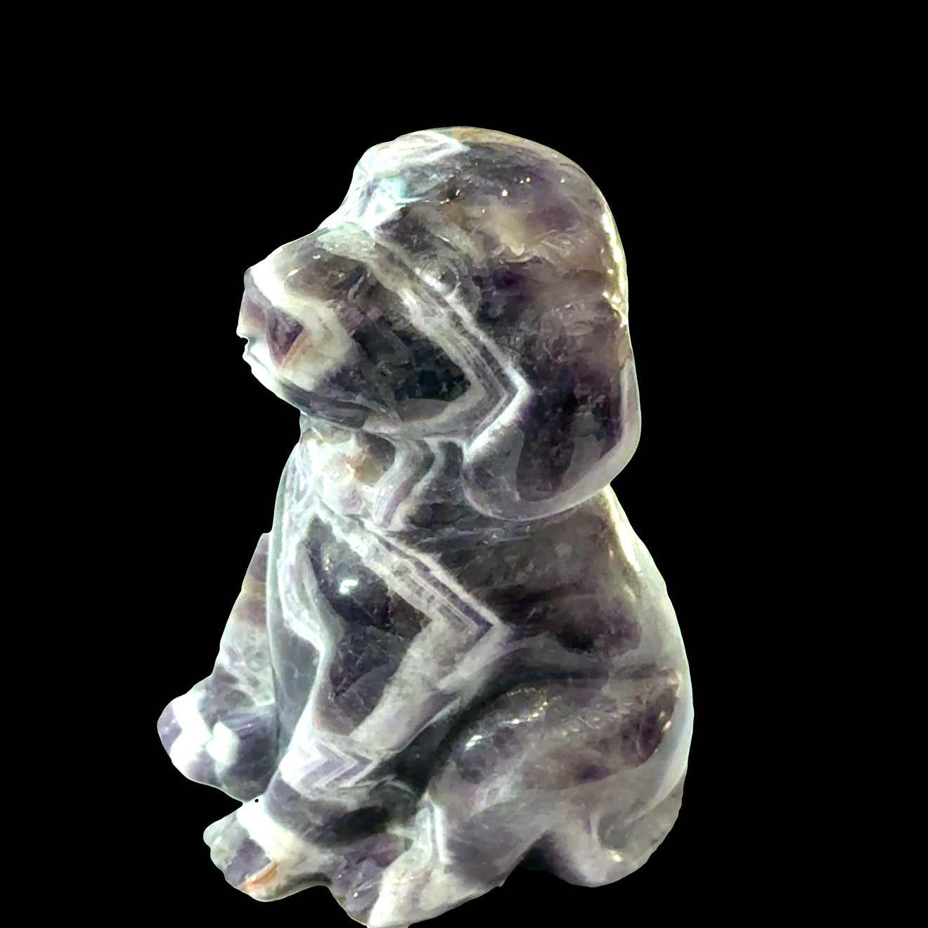 Amethyst Trapiche Gemstone Carved  Dog on a black background, right side view.