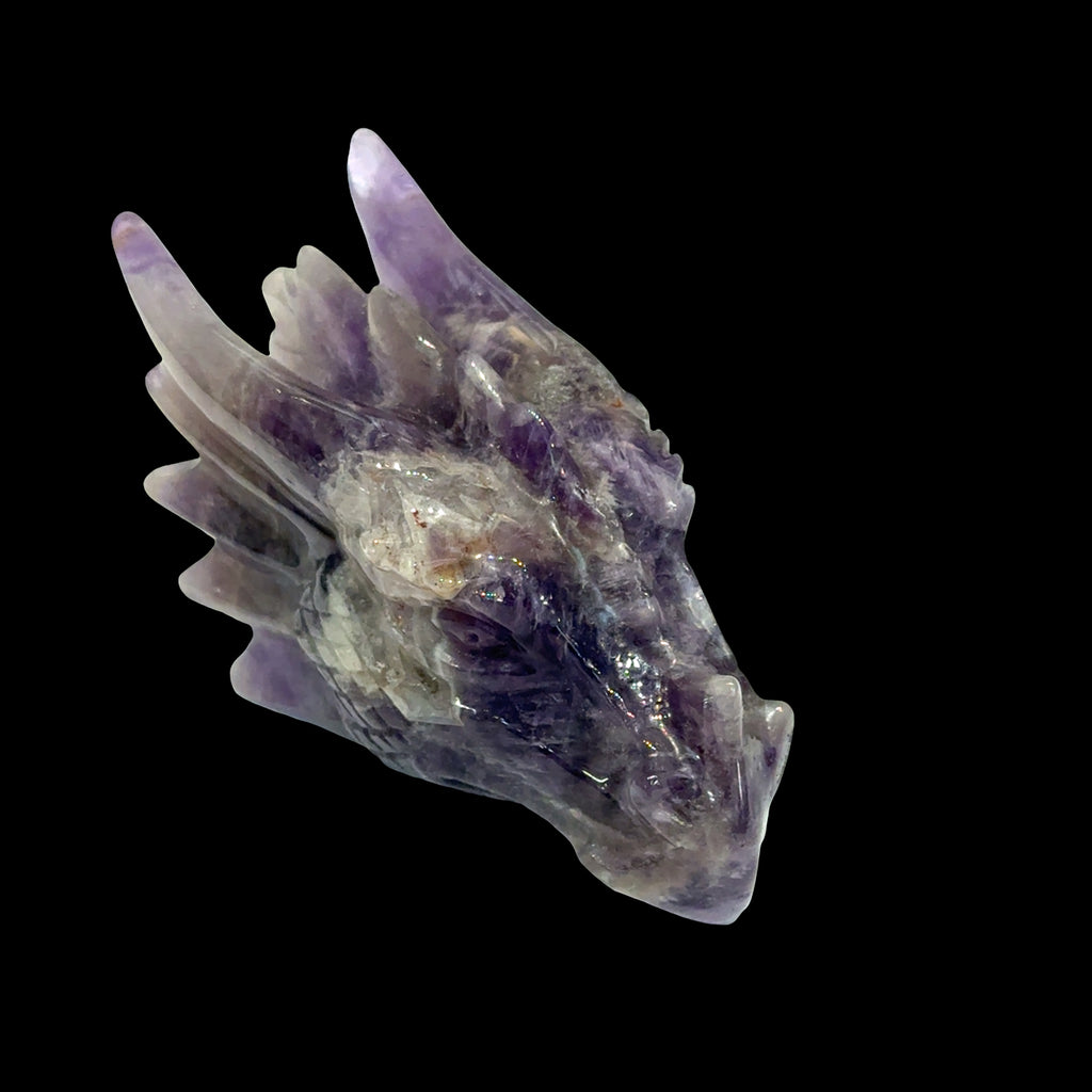 Amethyst gemstone dragon head carving, on a black background, front left angle view. 