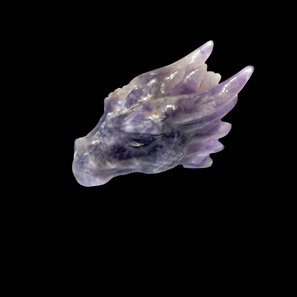 Amethyst gemstone dragon head carving, on a black background, front right angle view. 