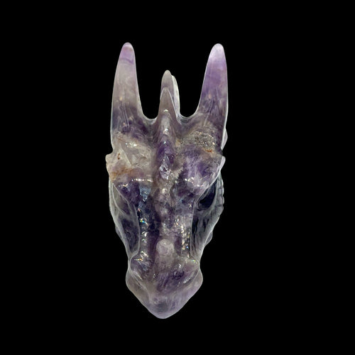 Amethyst gemstone dragon head carving, on a black background, front view. 