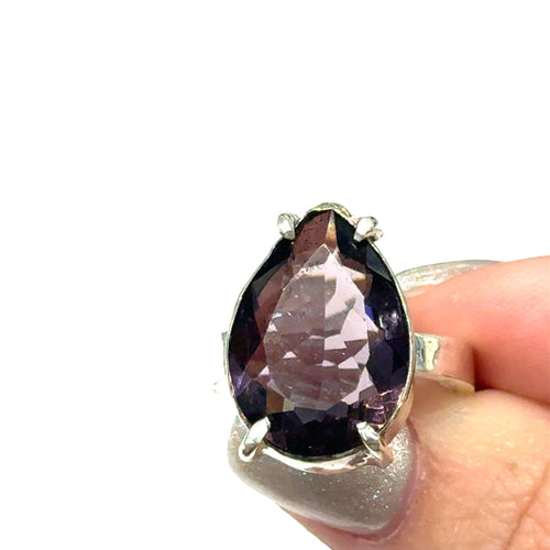 An Ametrine Ring with a purple teardrop-shaped gemstone held in a hand against a white background, front view.